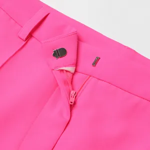 Detalle de primer plano del cierre de cremallera y gancho en un blazer rosa brillante de mujer