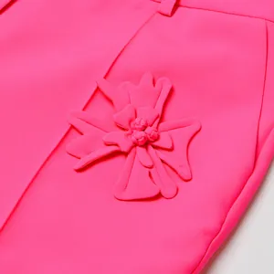 Primer plano de un blazer rosa vibrante con decoración de aplique de flor en tela 3D