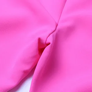 Vista macro de la textura del tejido rosa vibrante de la elegante chaqueta de mujer