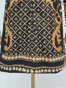 Detailed view of luxury French court style dress featuring gold prints and pearl beads