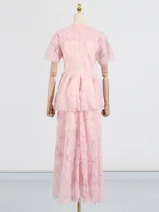 Elegante vestido largo rosa de tul bordado con volantes y hermosos motivos florales.