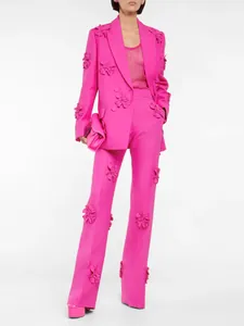 Traje fucsia para mujer con aplicaciones florales 3D en americana y pantalón.