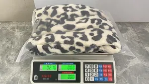 Chaleco de felpa de leopardo en balanza digital, muestra 0,210 kg para el peso.