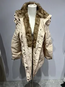 Détail d'un manteau d'hiver beige matelassé avec un grand col en fausse fourrure et capuche.