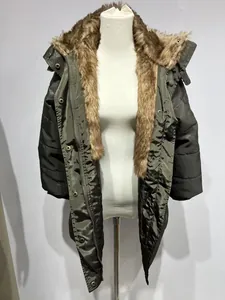 Vue détaillée d'une parka d'hiver pour femme avec grand col en fausse fourrure sur mannequin