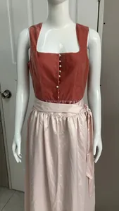 Vista dettagliata del corpino rosso mattone e del grembiule rosa di un Dirndl tipico