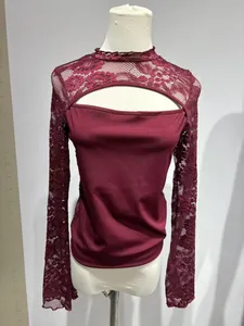 Detailansicht der eleganten Spitzenärmel und des Brustausschnitts an einem roten Oberteil