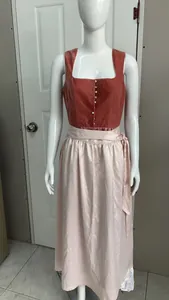 Vista completa di un abito tradizionale Dirndl rosso mattone con gonna in raso rosa