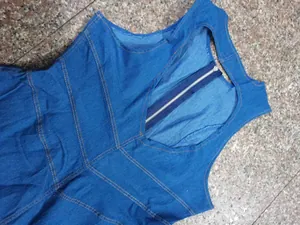 Close-up detail of the back metal zipper and stylish cutout design on blue denim jumpsuit.