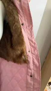 Détail en gros plan du col en fausse fourrure brune et doublure matelassée rose