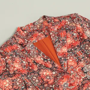 Close-up of elegant floral print and V-neck collar detail on a high-end dress jacket.