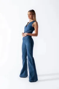 Side view of a professional model wearing a slim fit sleeveless high-waisted denim jumpsuit