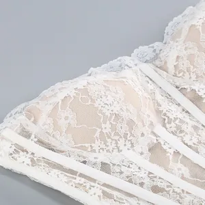Dettaglio ravvicinato dell'abito corsetto in pizzo floreale bianco con stecche.