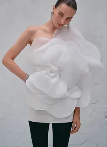 Detail showing the massive white 3D flower on a chic one-shoulder party dress