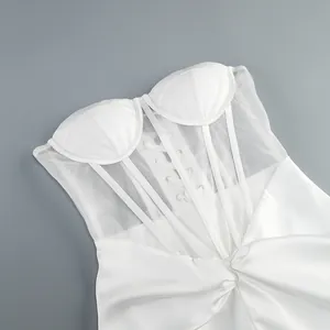 Dettaglio dell'abito a corsetto bianco con pannelli in rete e struttura steccata