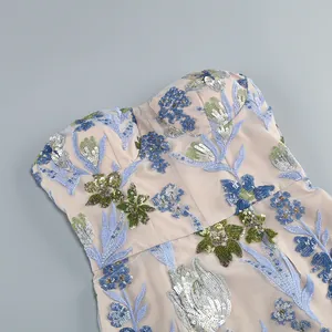 Gros plan de broderies florales et de paillettes sur une robe de soirée bustier.