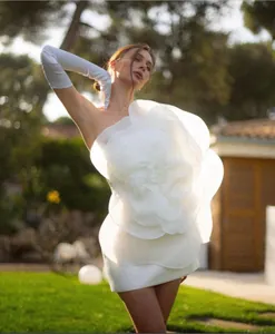 Detailed view of white one-shoulder mini dress with oversized 3D flower detail and gloves