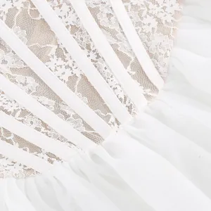 Dettaglio del corpino in pizzo bianco con stecche e gonna in tulle