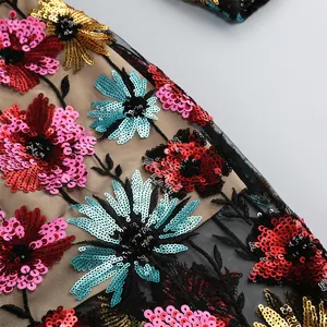 Gedetailleerde macro close-up van kleurrijke bloemen pailletten borduurwerk op mesh