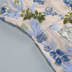 Détail de broderie florale à paillettes délicates sur une robe de soirée en mesh