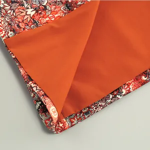 High-quality close-up showing intricate floral print fabric with bright orange lining