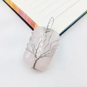 Detalle macro del árbol de la vida envuelto en hilo de plata sobre cuarzo rosa