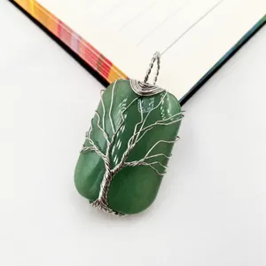 Detail of handmade wire wrapped green gemstone pendant with Tree of Life design.