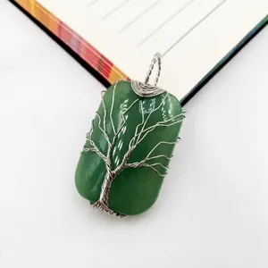 Detalle del colgante de piedra verde con diseño de Árbol de la Vida hecho a mano.