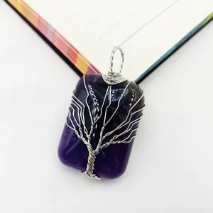 Detalle de un colgante rectangular de amatista hecho a mano con el árbol de la vida