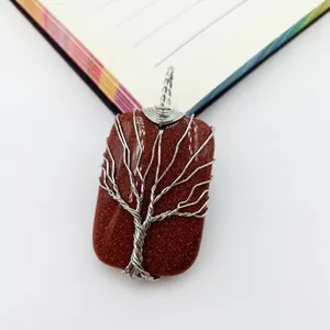 Macro detail of a handmade silver wire wrapped tree of life on goldstone pendant