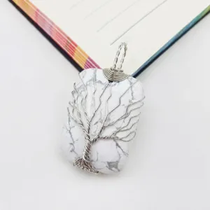 Detalle macro del árbol de la vida hecho a mano en un colgante rectangular de piedra blanca