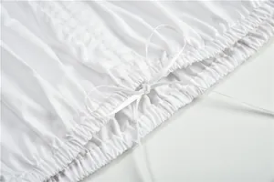 Nahaufnahme der weißen Baumwollstoff-Details mit elastischen Raffungen und Schleifenschmuck