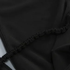 Close-up macro view of the ruched elastic fabric detail on a sexy black bodycon halter dress