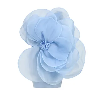 Close-up of large layered fabric flower detail on light blue party dress.