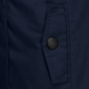 Close-up detail of navy blue jacket pocket with a black textured button.