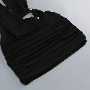 Close-up of black ruched bodycon dress detailing triangle ring and soft fabric texture