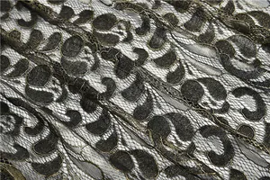 Nahaufnahme der aufwendigen schwarz-goldenen Jacquard-Spitze mit feinen Metallfäden