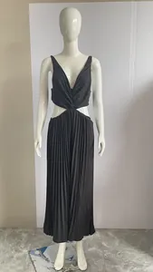 Detail of elegant black pleated maxi dress featuring waist cut-outs and deep V-neckline