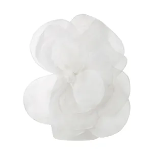 Close-up detail of a large white organza fabric flower decoration for party dresses.