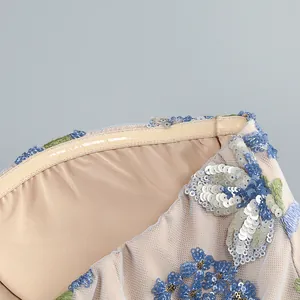 Vue détaillée des broderies de fleurs à paillettes sur le corsage de la robe