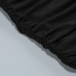 Close-up macro shot showing the fine ruched elastic detail on a black bodycon halter dress fabric