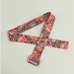 Detailed view of a wide floral print fabric belt with a matching rectangular buckle
