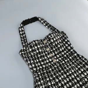 Detalle de vestido halter de tweed blanco y negro con lentejuelas y botones dorados