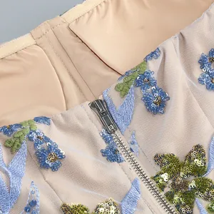 Détail du zip métallique et de la broderie de fleurs à paillettes sur une robe bustier
