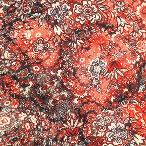 Close-up of intricate red bohemian floral print fabric for elegant V-neck dresses.