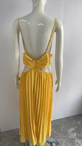 Detail of a yellow pleated backless maxi dress with cut-out waist on a mannequin