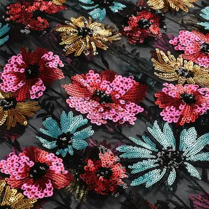 Macro-opname van kleurrijk bloemenborduurwerk met pailletten op elegante zwarte mesh stof