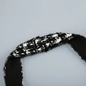 Primer plano de un tirante de cuello halter de tweed blanco y negro con lentejuelas