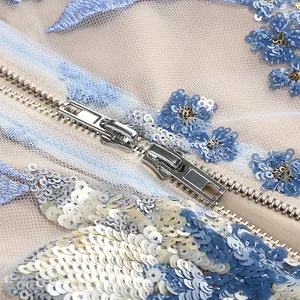 Gros plan d'une fermeture éclair en métal sur une robe de soirée brodée à sequins