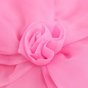 Exquisite close-up of a handmade chiffon fabric flower on a pink elegant party dress